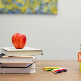 stack of books, blocks, pencils and apple