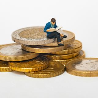 person reading sitting on euro coins