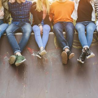 young people sitting on a wall 