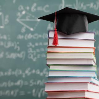 books with a graduation cap on top of them