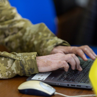 Person in military writing on laptop Person in military writing on laptop